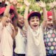 youth summer learning grants: happy children raising hands outside