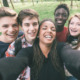 Peacebuilding youth opportunity: Group of five teens standing close together taking selfie